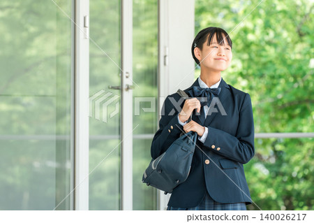 身穿校服的中學生和高中女生走在學校走廊上。 身穿校服的中學生和高中女生走在學校走廊上。 140026217