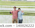 Two farmers giving a thumbs-up in a rice field. Two farmers giving a thumbs-up in a rice field. 140026222