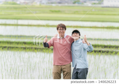 兩名農民在稻田裡豎起大拇指。 140026223