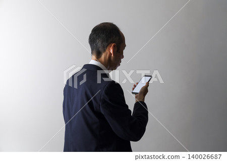 日本中年男子低頭看著他們的智慧型手機 日本中年男子低頭看著他們的智慧型手機 140026687