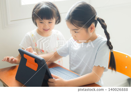 一位小學生正在用平板電腦學習。 一位小學生正在用平板電腦學習。 140026888