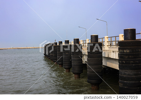 Concrete Pillars Structure Over The Sea, A striking photo of concrete pillars structure, tall gray rising from water in bright, perfect for coastal engineering or architecture documentary. 140027059
