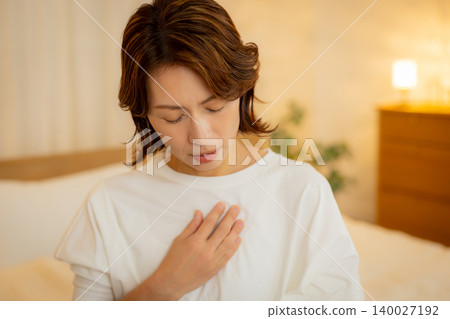 A woman feeling unwell in her bedroom at night 140027192