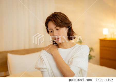 A woman feeling unwell in her bedroom at night A woman feeling unwell in her bedroom at night 140027196