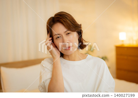 A woman feeling unwell in her bedroom at night A woman feeling unwell in her bedroom at night 140027199