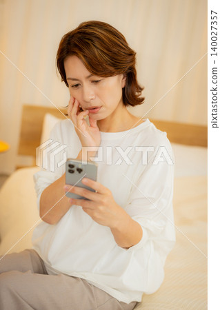 woman looking at smartphone at night woman looking at smartphone at night 140027357