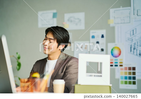 A male chief designer brainstorming ideas. A male chief designer brainstorming ideas. 140027665