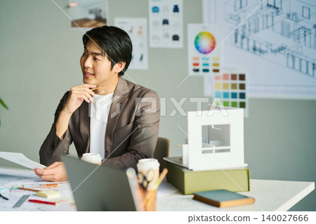 A male chief designer brainstorming ideas. A male chief designer brainstorming ideas. 140027666