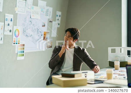一位男性首席設計師正在集思廣益。 一位男性首席設計師正在集思廣益。 140027670