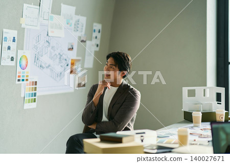 A male chief designer brainstorming ideas. A male chief designer brainstorming ideas. 140027671