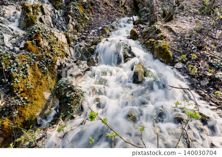 Cascade waterfall falling on rocks in forest, long exposure 140030704