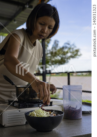 Woman Garnishing Kanom Jeen Nam Ngiew In A Bowl, chef preparing authentic thai noodle soup for restaurant menu marketing campaign, brand awareness, traditional asian culinary food and lifestyle. Woman Garnishing Kanom Jeen Nam Ngiew In A Bowl, chef preparing authentic thai noodle soup for restaurant menu marketing campaign, brand awareness, traditional asian culinary food and lifestyle. 140031323