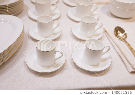 White espresso cups and saucers arranged on linen table White espresso cups and saucers arranged on linen table 140031556