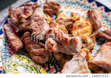 Grilled pork and chicken slices arranged on ceramic plate Grilled pork and chicken slices arranged on ceramic plate 140031575
