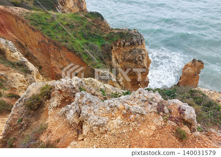 Rugged coastal cliffs overlooking ocean waves Rugged coastal cliffs overlooking ocean waves 140031579