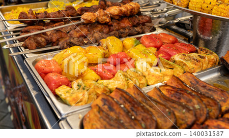 Grilled vegetables and meat skewers at a vibrant outdoor market Grilled vegetables and meat skewers at a vibrant outdoor market 140031587