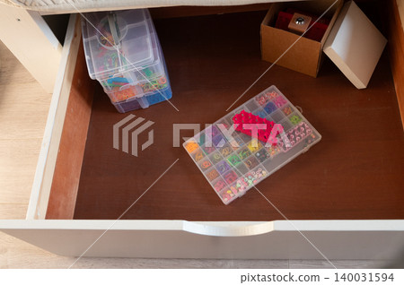 Organized drawer with craft storage boxes and colorful beads Organized drawer with craft storage boxes and colorful beads 140031594