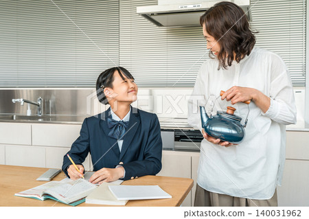 A girl in a uniform studying and a mother watching her daughter study in the middle of housework A girl in a uniform studying and a mother watching her daughter study in the middle of housework 140031962
