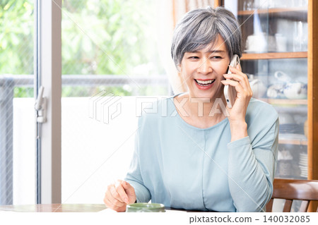 一位老婦人在家打電話 140032085