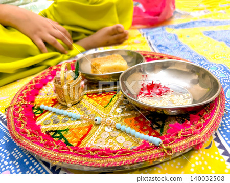 Raksha Bandhan thali with rakhi, rice, kumkum and sweets on a decorated plate. Raksha Bandhan thali with rakhi, rice, kumkum and sweets on a decorated plate. 140032508