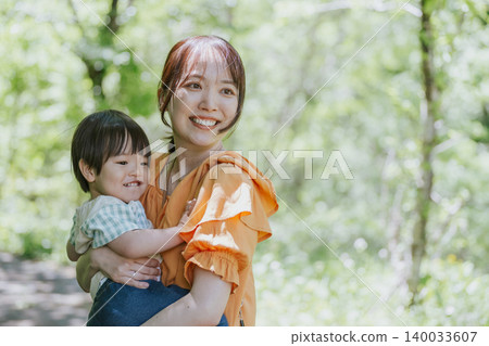 一位母親和孩子在大自然中玩耍。 一位母親和孩子在大自然中玩耍。 140033607
