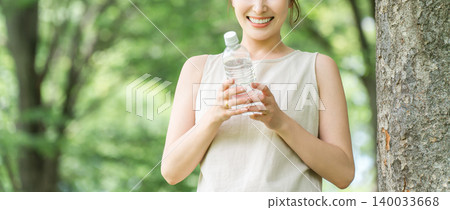 A relaxed woman drinking bottled water, mineral water, and hot water. A relaxed woman drinking bottled water, mineral water, and hot water. 140033668
