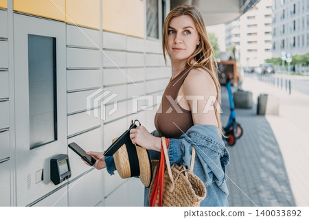 Woman holds smartphone near automated package terminal and shopping bags. Smart city retail infrastructure, urban technology integration service, automated neighborhood locker hub. Woman holds smartphone near automated package terminal and shopping bags. Smart city retail infrastructure, urban technology integration service, automated neighborhood locker hub. 140033892