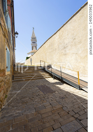 A stone paved alleyway leads upwards towards a distant bell tower in Piran, Slovenia A stone paved alleyway leads upwards towards a distant bell tower in Piran, Slovenia 140033962