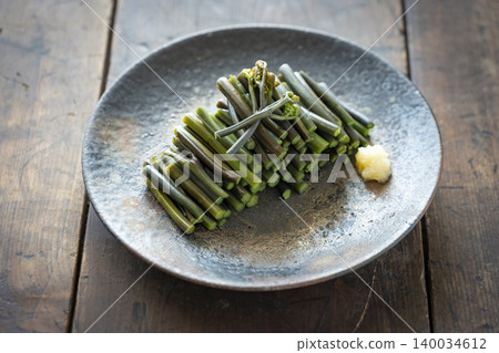 汆燙過的蕨菜配上磨碎的生薑，盛於民間陶罐中，是一道春季野生蔬菜菜餚。 140034612