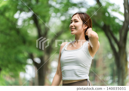 A woman sunbathing outdoors in a park (sunlight, serotonin, sunscreen, UV rays, skincare) A woman sunbathing outdoors in a park (sunlight, serotonin, sunscreen, UV rays, skincare) 140035031
