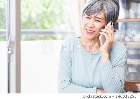 一位老婦人在家打電話 140035253