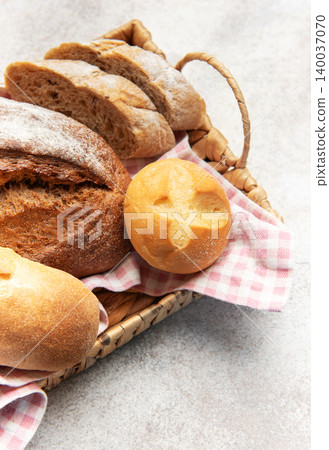Assorted fresh crusty bread loaves in rustic basket Assorted fresh crusty bread loaves in rustic basket 140037070