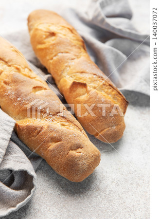 Fresh crisp baguettes on rustic linen cloth Fresh crisp baguettes on rustic linen cloth 140037072