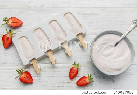 Homemade strawberry yogurt popsicles chilling in mold 140037092