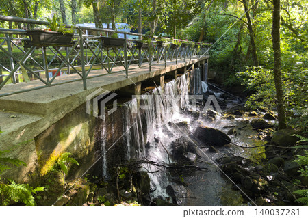 Small Waterfall under a Pedestrian Bridge at Parque de Lazer da Varzea Small Waterfall under a Pedestrian Bridge at Parque de Lazer da Varzea 140037281