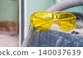 Pair of yellow amber plastic safety glasses for safe work during construction, renovation, repair and maintenance. PPE protective accessory. Lightweight polycarbonate construction for industrial work 140037639