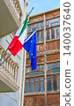 Italian and EU flags against historic buildings in Baku, Azerbaijan. Flag of Italy and European Union together. Flag day celebration, patriotism. Embassies and consulates of countries 140037640