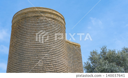 Maiden Tower or Qiz Qalasi, iconic 12th century monument in Old City, Icherisheher of Baku, Azerbaijan. Blue sky and olive tree on background, copy space. Traveling and tourism, famous spots 140037641