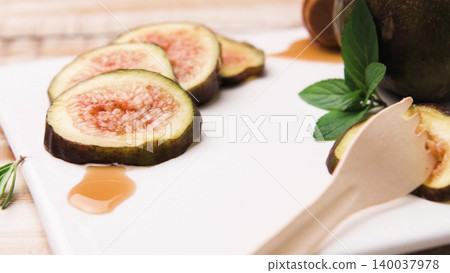 Fresh Sliced Figs with Honey and Mint on a White Platter Fresh Sliced Figs with Honey and Mint on a White Platter 140037978