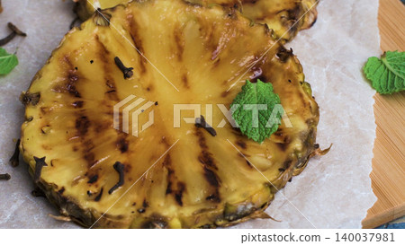 Grilled Pineapple Slice Garnished with Whole Cloves and Fresh Mint Leaves Grilled Pineapple Slice Garnished with Whole Cloves and Fresh Mint Leaves 140037981