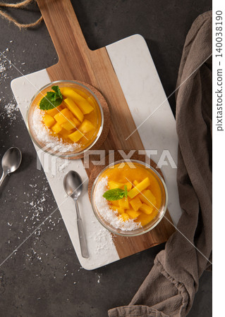 Fresh Mango Mousse with Shaved Coconut and Mint Garnish on Marble Serving Board Fresh Mango Mousse with Shaved Coconut and Mint Garnish on Marble Serving Board 140038190