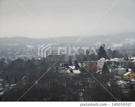 Softly blurred valley with scattered homes and leafless trees illustrates peaceful winter solitude Softly blurred valley with scattered homes and leafless trees illustrates peaceful winter solitude 140039387