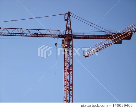 Elegant steel lattice of crane outlined sharply with clear blue backdrop renewing modern construction imagery Elegant steel lattice of crane outlined sharply with clear blue backdrop renewing modern construction imagery 140039403