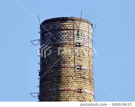 Industrial chimney closeup. Closeup of deteriorated industrial chimney with safety hazard Industrial chimney closeup. Closeup of deteriorated industrial chimney with safety hazard 140039415