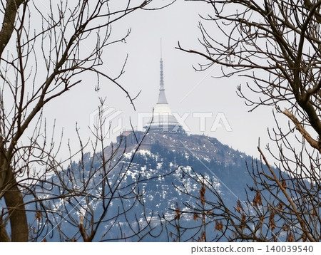 Snowy peak hosts communication tower. Frozen summit displays radio antennas in chilly winter setting Snowy peak hosts communication tower. Frozen summit displays radio antennas in chilly winter setting 140039540