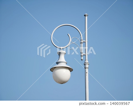 Decorative light against blue sky. Stylish lamp with detailed features against bright daytime sky Decorative light against blue sky. Stylish lamp with detailed features against bright daytime sky 140039567
