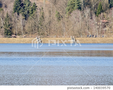 Tranquil lakeside with natural features. Calm water setting with shoreline steps and surrounding vegetation 140039570