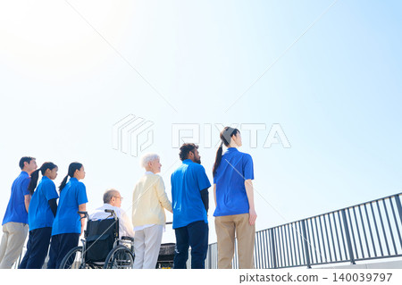 一名日本人、一名外國護理人員和一位老人（從背後）抬頭望向天空 140039797