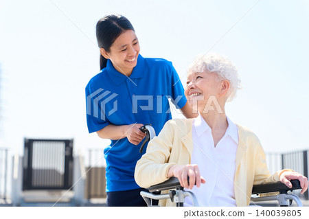 Senior citizen and foreign caregiver exchange smiles. Senior citizen and foreign caregiver exchange smiles. 140039805