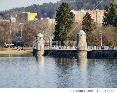 Vertical stone towers secured on lakeshore with detailed craftsmanship and surrounding nature elements Vertical stone towers secured on lakeshore with detailed craftsmanship and surrounding nature elements 140039979